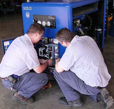 men working on air compressor
